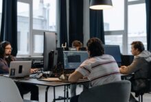 Team of developers working together on computers in a modern tech office.