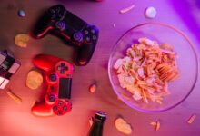 Overhead view of game controllers and snacks on a table, perfect for a gaming night setup.