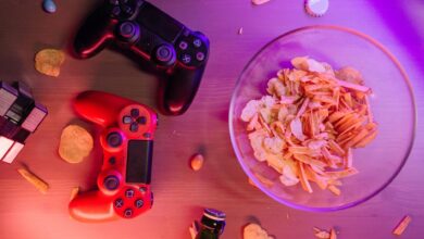 Overhead view of game controllers and snacks on a table, perfect for a gaming night setup.