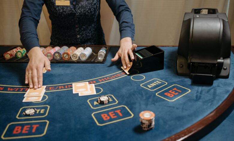 Casino dealer organizing cards and chips on a gaming table during a game.