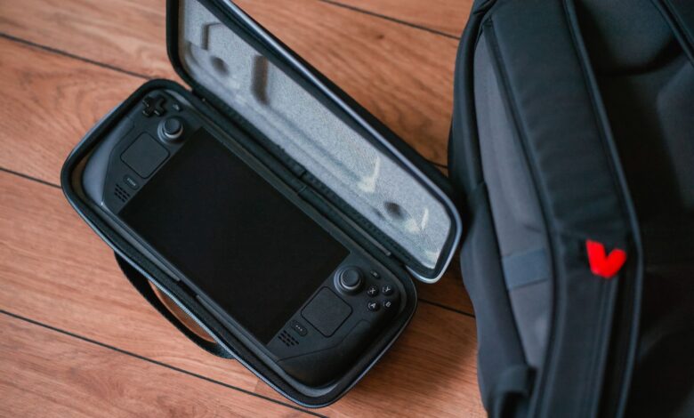 A close-up shot of a gaming console in its case next to a backpack on a wooden floor.