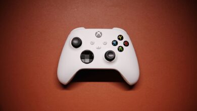 White Xbox controller isolated on a red background with shadows.