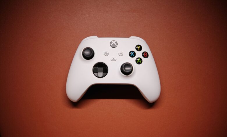White Xbox controller isolated on a red background with shadows.