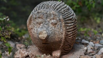 Artistic stone hedgehog sculpture in outdoors with nature background.