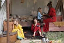 Family scene depicting children and adult in historical tent setting with vintage garments.