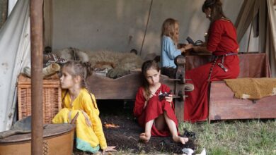 Family scene depicting children and adult in historical tent setting with vintage garments.