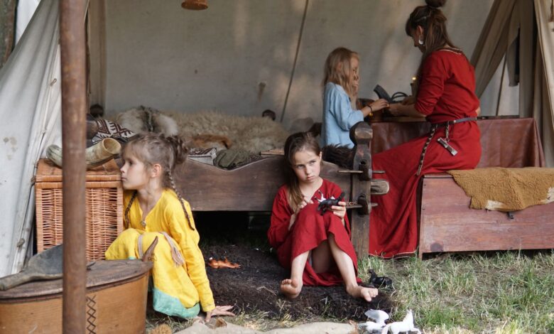 Family scene depicting children and adult in historical tent setting with vintage garments.