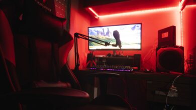 Sleek gaming setup featuring a microphone, neon lights, and a gaming chair in a home studio.