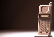 Vintage mobile phone with keypad and antenna on a dark background, emphasizing retro technology.