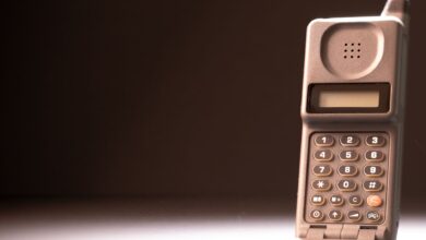 Vintage mobile phone with keypad and antenna on a dark background, emphasizing retro technology.