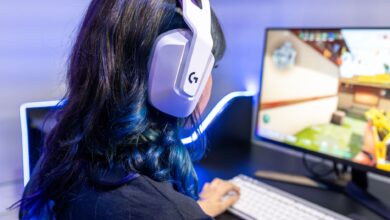 A young gamer playing an online game while wearing headphones, focused on the screen.