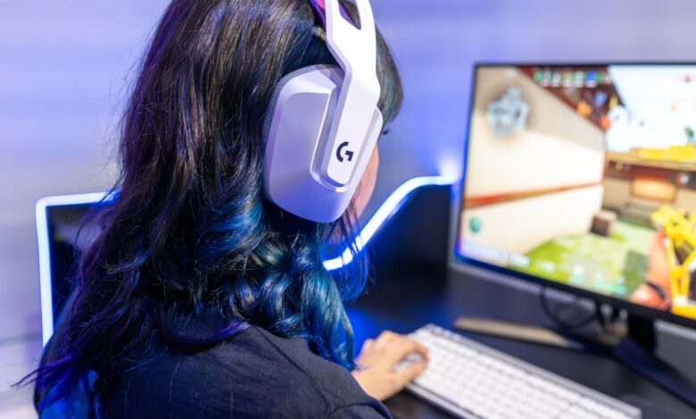 A young gamer playing an online game while wearing headphones, focused on the screen.