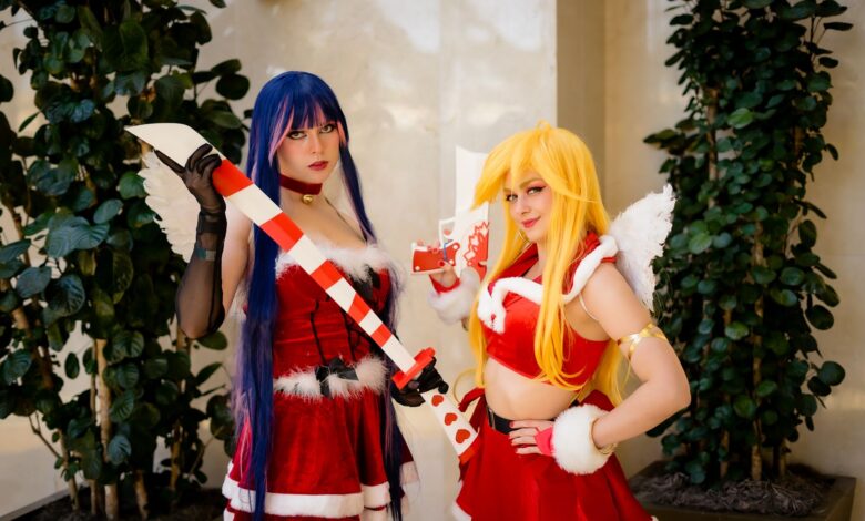 Two cosplayers in Christmas-themed costumes with props at an anime convention in Orlando.