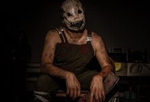 Dramatic portrait of a person wearing a terrifying horror mask and costume, perfect for Halloween themes.