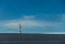 A modern telecommunication tower stands against a clear blue sky, showcasing technological advancement.