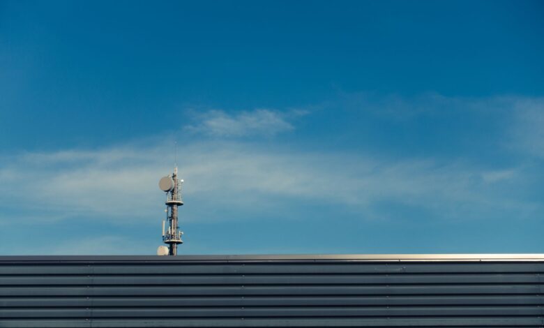 A modern telecommunication tower stands against a clear blue sky, showcasing technological advancement.