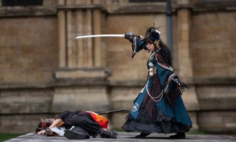 Dramatic outdoor cosplay scene with sword fight and elaborate costumes.