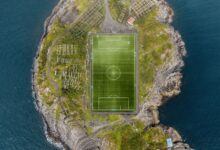 Stunning aerial view of the Henningsvær soccer field surrounded by the sea in Norway.