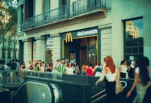 Crowded street scene outside McDonald's with diverse pedestrians.