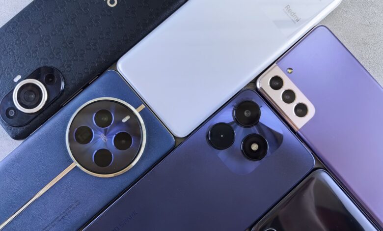 Top view of various modern smartphones showcasing diverse camera designs on flat surface.