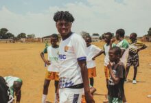 Youth soccer players gathered on a sunny day at an outdoor field, showcasing teamwork and camaraderie.