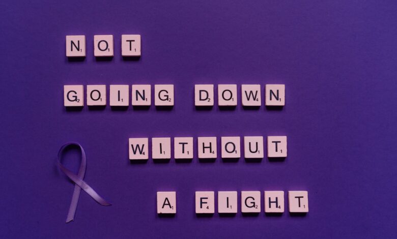 Scrabble tiles with an inspiring quote and a purple ribbon on a purple background.