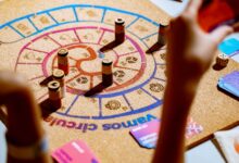 Players engaging in a vibrant strategy board game with colorful pieces and cards.