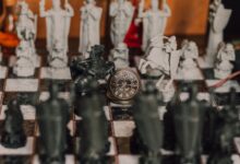 Detailed close-up of a medieval-themed chess set with ornate pieces on a chessboard.