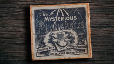 Antique mysterious planchette game board on rustic wooden surface.