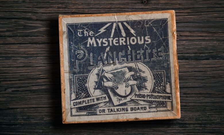 Antique mysterious planchette game board on rustic wooden surface.