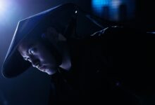 Dramatic low-key portrait of a cosplayer dressed as a game character, indoors, studio lighting.