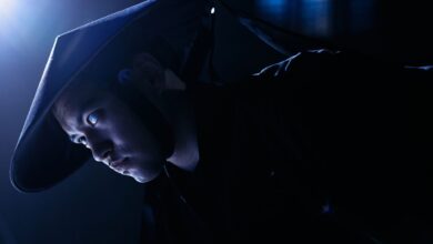 Dramatic low-key portrait of a cosplayer dressed as a game character, indoors, studio lighting.