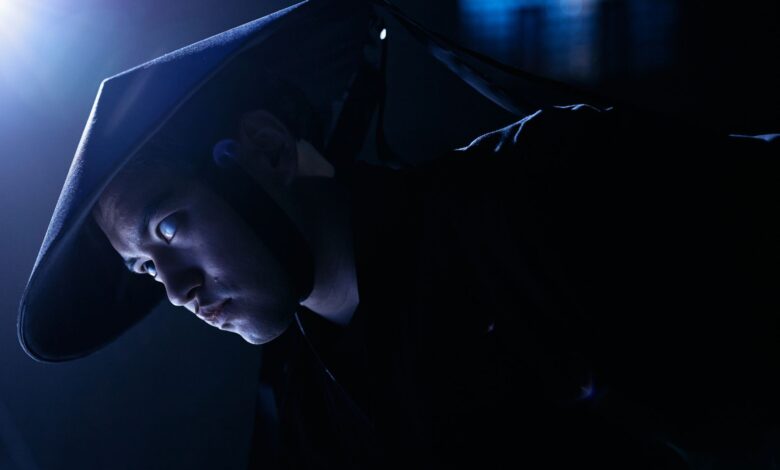 Dramatic low-key portrait of a cosplayer dressed as a game character, indoors, studio lighting.