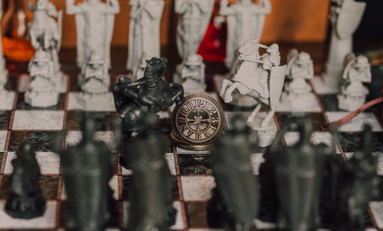 Detailed close-up of a medieval-themed chess set with ornate pieces on a chessboard.
