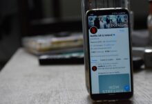 Smartphone showing Netflix's Twitter page on a wooden table.