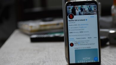 Smartphone showing Netflix's Twitter page on a wooden table.