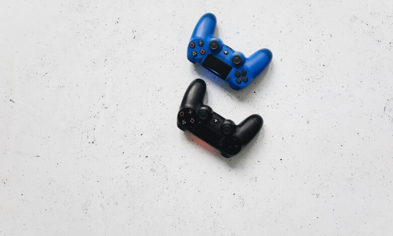 Blue and black PlayStation controllers on a white speckled surface captured from above.