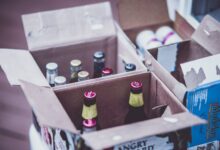 Variety of beer bottles displayed in open cardboard boxes.