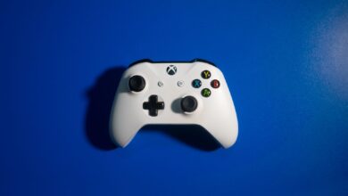 White wireless game controller on a vibrant blue backdrop, perfect for gaming-related content.