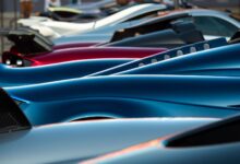 A stunning display of sleek hypercars showcasing premium designs and vibrant colors at an exhibition.