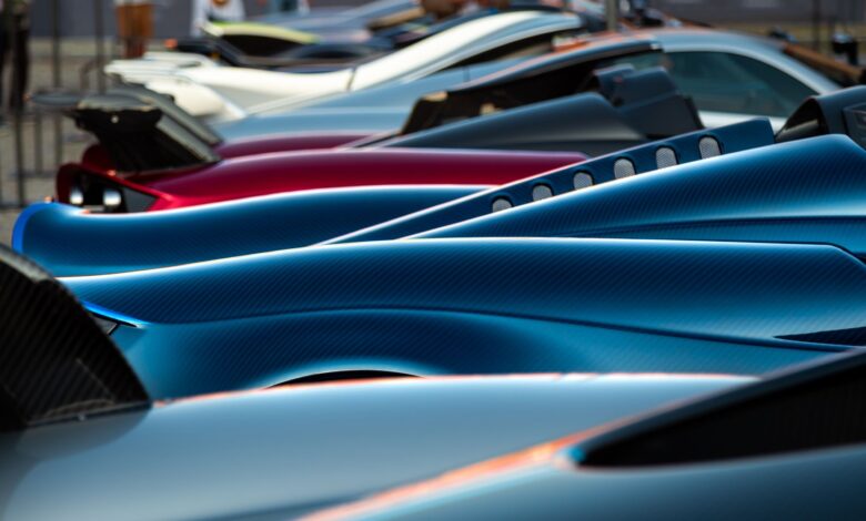 A stunning display of sleek hypercars showcasing premium designs and vibrant colors at an exhibition.