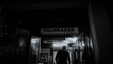 An individual enters a filmmaker-themed building at night, evoking a mysterious artistic vibe.
