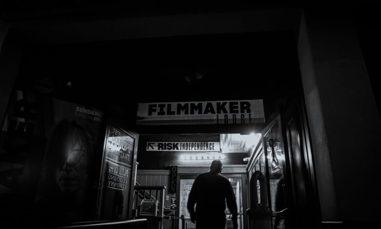 An individual enters a filmmaker-themed building at night, evoking a mysterious artistic vibe.