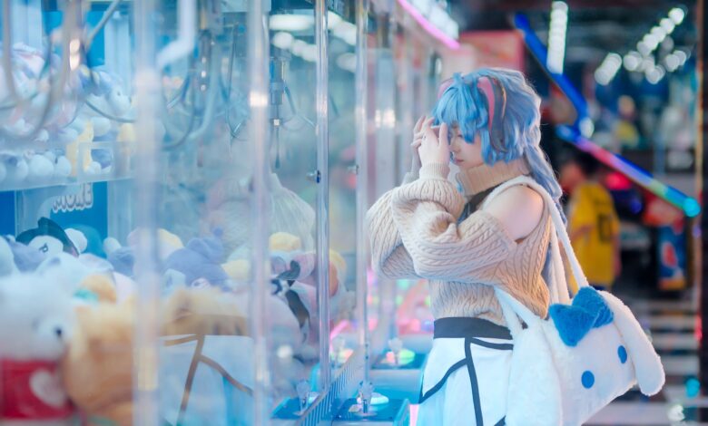 Cosplayer in vibrant outfit plays a claw machine in a colorful arcade setting in Vietnam.