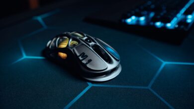 High-tech gaming mouse on illuminated hexagonal pattern mousepad, perfect for gamers.