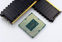 A CPU and RAM sticks displayed on a white surface, showcasing computer hardware components.