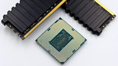 A CPU and RAM sticks displayed on a white surface, showcasing computer hardware components.