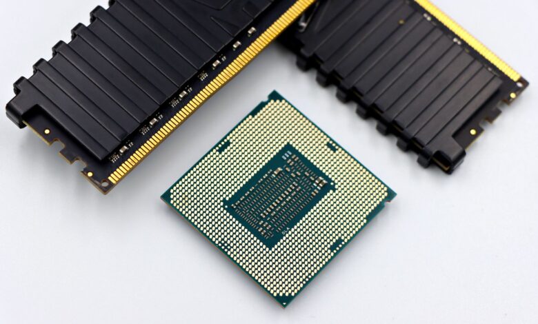 A CPU and RAM sticks displayed on a white surface, showcasing computer hardware components.