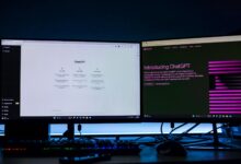 Dual computer monitors showcasing a chat interface in a technology workspace setting.