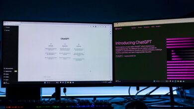 Dual computer monitors showcasing a chat interface in a technology workspace setting.